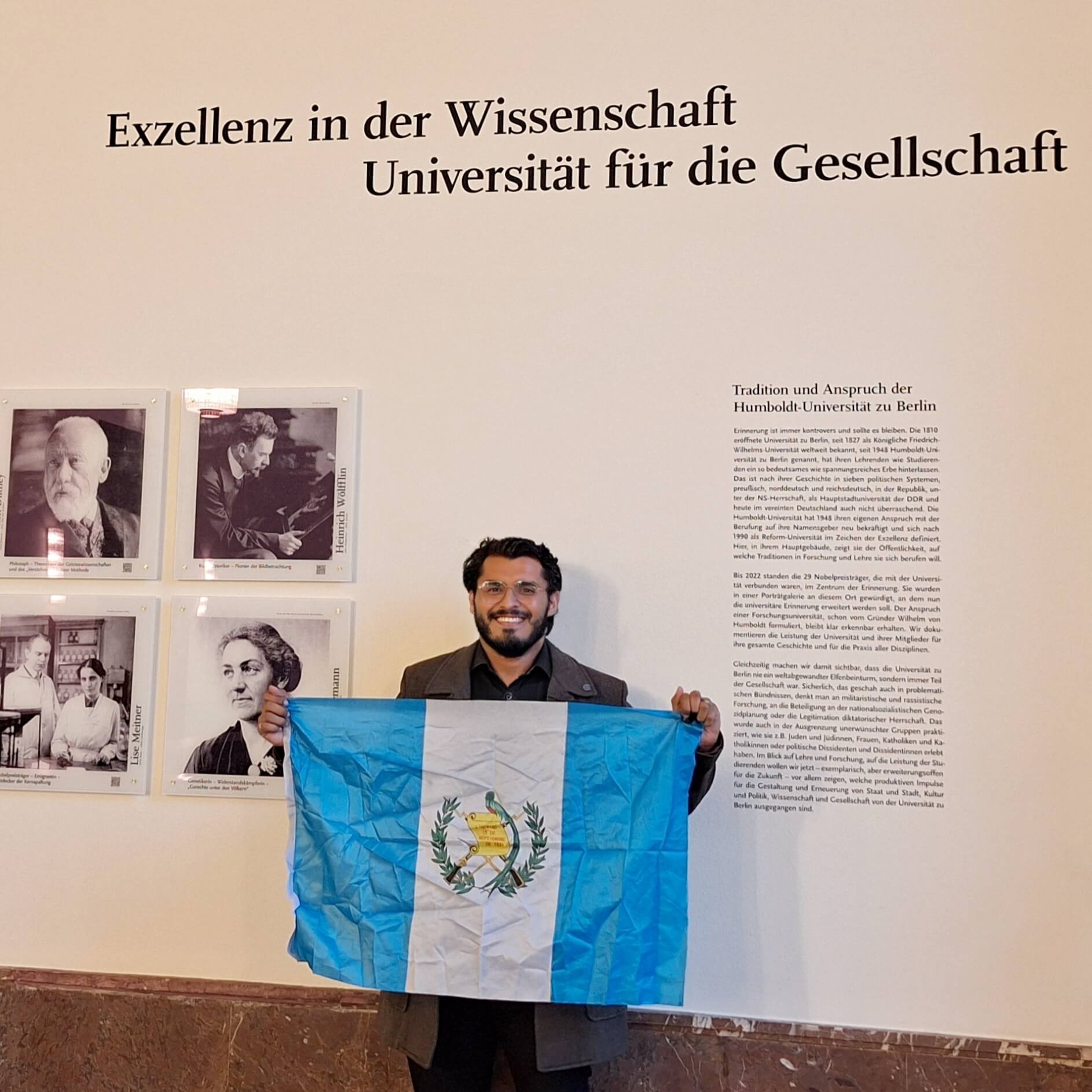 Oscar Morales Cuellar en la Universidad Humboldt de Berlín con la bandera de Guatemala